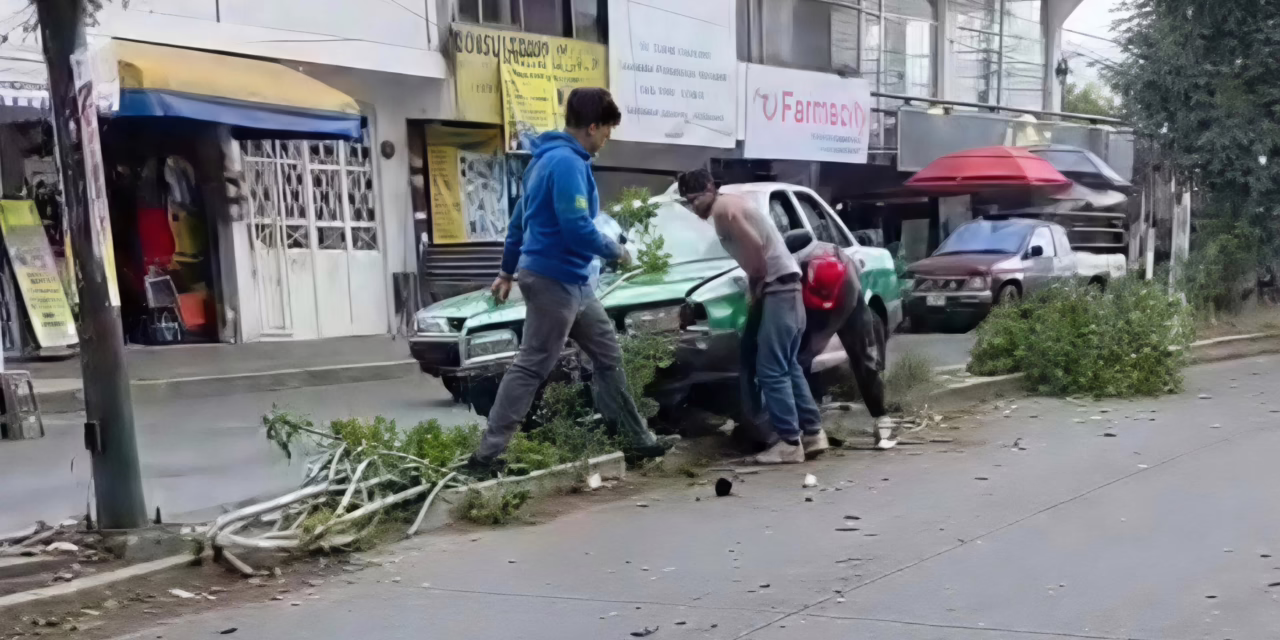 Taxi queda varado sobre camellón de la colonia Revolución; chofer y testigos intentaron moverlo